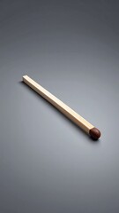 Single matchstick on gray background