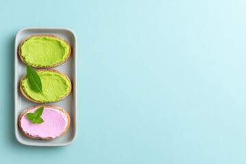 Delicate slices of bread topped with vibrant green and pink spre
