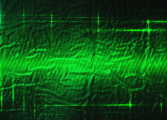 Textured surface illuminated with green light. Light horizontal and vertical lines are superimposed on the material