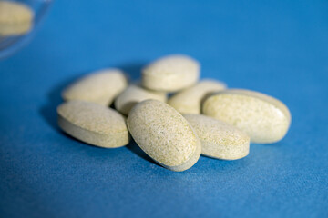Tablets of Natural Sulforaphane Supplements on Blue Background