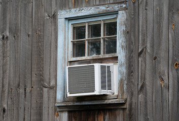 old air conditioner installed on old wood wall building