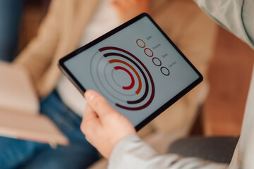 Businessman holding tablet showing financial charts during meeting