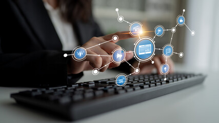 A business professional engages with digital marketing icons on a keyboard, illustrating the...