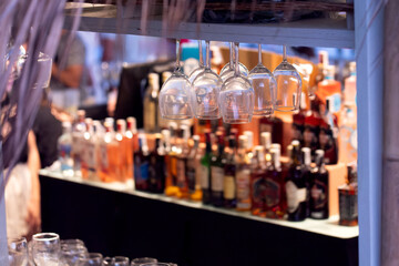 Close-up of clean wine glasses hanging in a bar