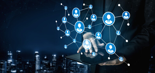 A professional individual utilizes a tablet to interact with dynamic networking connections, showcasing the essence of modern business communication and digital interaction. Tessel