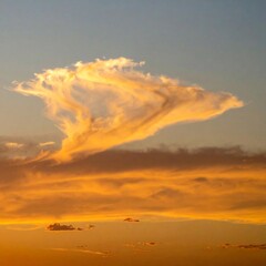 Fototapeta premium Dramatic Sky with Golden Light and Towering Cloud Formation at Sunset Blue Sky Above