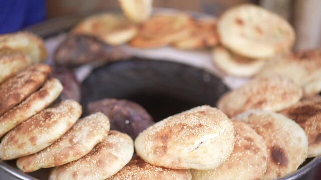 Traditional round naan bread freshly baked in a Xinjiang tandoor oven with golden crust and rustic texture