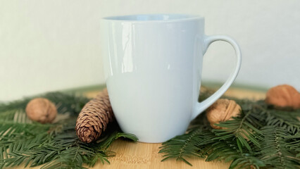 White Mug With Pine Cones And Walnuts On Evergreen Branches — Winter Decoration Mockup With Copy Space For Banner, Branding And Template Design
