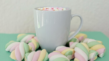 Hot Chocolate With Mini Marshmallows In White Mug, Marshmallow Twists Around On Green Background — Cozy Dessert Texture Mockup With Copy Space For Banner, Branding And Template Design