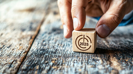 Hand Placing Wooden Block Marked 2025 on Rustic Table Surface with Textured Background