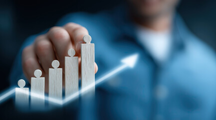 Professional businessman presenting wooden growth chart figures with upward trending arrow.