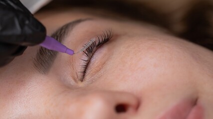 The process of professional eyelash lamination in a salon. 