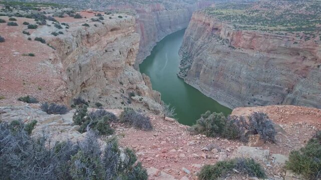 A breathtaking scenic view of a golden sunset from Devil's Canyon Overlook, casting a warm glow over the dramatic landscape of Bighorn Canyon