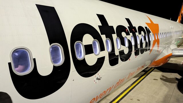 Closeup of Jetstar airplane with logo and branding on airport runway in Auckland, New Zealand Aotearoa - taken on 3 Sept 2025