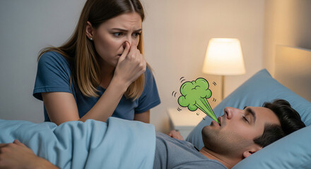 Young woman pinching her nose in disgust due to bad breath from her husband sleeping in bed