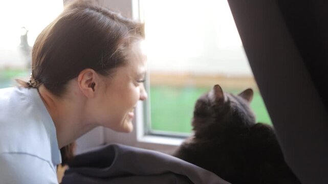 a woman playing with a cat at home