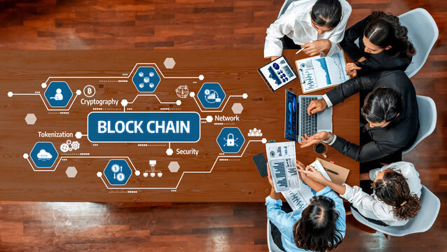 A diverse business team engages in a focused discussion on blockchain technology, analyzing data and strategies to enhance security and innovation in their operations. Amity