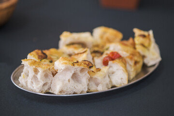 Freshly baked focaccia bread slices with golden crust and airy texture on a tray