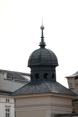 Small architectural dome with ornate spire and circular openings crowns historic building, representing heritage, craftsmanship, and urban tradition