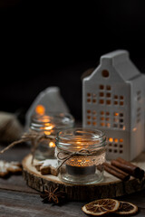 Creative handmade christmas home decor decorations: simple glass jars with aroma candles decorated with a ribbon, cinnamon, anise, dry orange. Cozy atmospheric composition for holiday mood creation