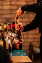 Sommelier opening wine bottle at elegant tasting event with glasses on table