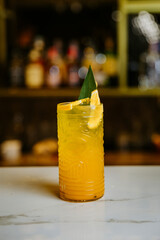 Refreshing tropical cocktail in a tiki glass with citrus garnish on a bar counter
