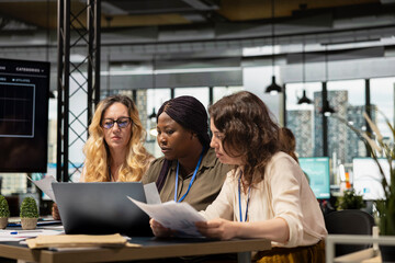 Team of career focused women aligning analytics and objectives, reviewing financial performance data to lead company toward success in a smart and collaborative work environment.