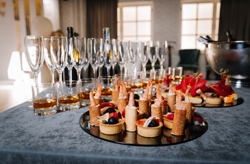 Elegant catering setup with gourmet canapes and whiskey in glasses for a corporate event