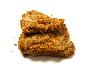Fine breaded chicken breast fillet on white background. Classic poultry product. Uncooked meat covered with golden breadcrumbs.