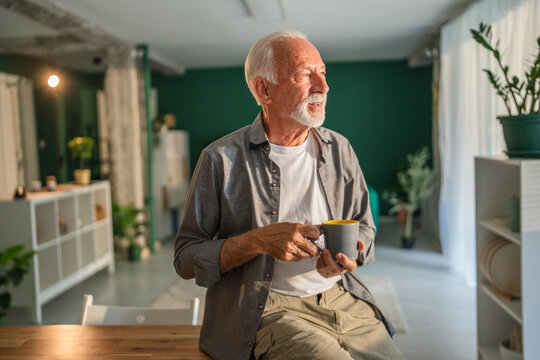 Senior man enjoying a cup of coffee at home in the morning