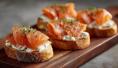Smoked salmon appetizers on toasted bread. Four small open-faced sandwiches, topped with layers of  smoked salmon and a creamy cheese spread, garnished with fresh herbs