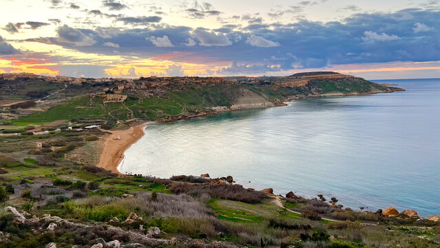 Golden sunset illuminating ramla bay, gozo, malta: a breathtaking coastal vista