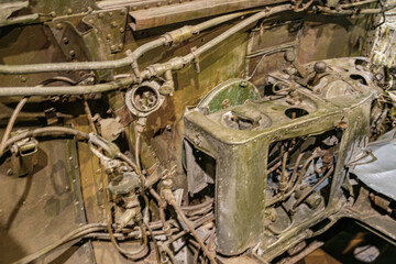 Close-up view of a corroded aircraft engine in an indoor industrial space, with multiple pipes and...