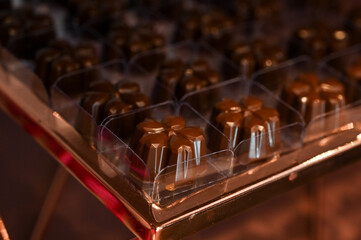 artisanal dark chocolate truffles in packaging, gourmet sweets for a party or event, delicious homemade confectionery for sale, luxurious bonbons in a box with soft light

