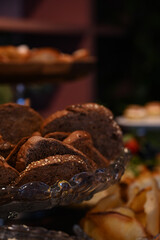 sliced dark grain bread with seeds for a party, fresh loaves of whole grain bread served on a plate, assorted artisanal breads and rolls for a buffet, healthy and rustic bread for a special breakfast
