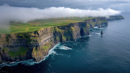 Dramatic coastal cliffs meet a churning sea, shrouded in mist