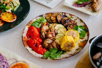 Grilled vegetables with herbs on ceramic plate. Colorful healthy vegan meal top view