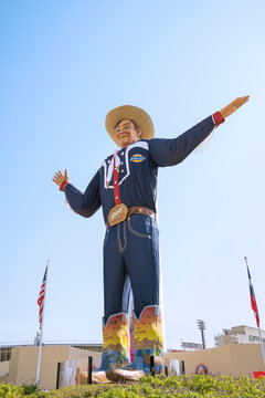 Closeup of the Big Tex statue at Fair Park, Dallas, Texas. The figure icon greets and waves his hands to welcome visitors at the State Fair of Texas fairgrounds.