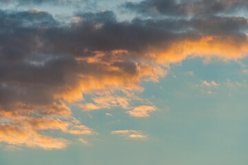 Cloud formation over serene twilight sky, orange, yellow, grey tones, subtle gradient, open expanse, realistic style, attention to natural lighting effects