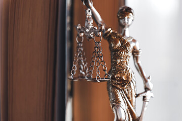 Criminal, civil, administrative and labor law. Trial and prosecution. Justice and fairness concept.Goddess Themis statuette in golden clothes with scales in her hands 