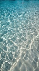 Shallow, sunlit water surface.  Rippled, textured light patterns on the ocean floor