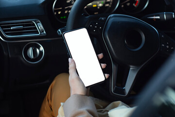 Mockup smartphone with blank white screen in female hand inside modern car interior. Template for app presentation and UI UX design showcase.