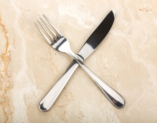 Silver cutlery crossed on beige marble