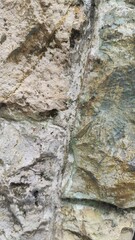 Close-up of rough stone wall texture with natural cracks and details. Perfect for use as a background, architectural design, construction material reference, or texture mapping in 3D and graphic proje