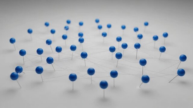 Blue Push Pins Connected by String Network on White Surface