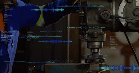 Operating machinist wearing blue coveralls adjusting mill controls at workshop, with code overlays