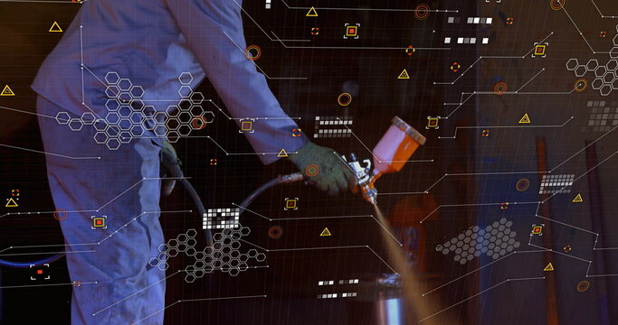 Spraying barrel by painter wearing coverall, gloves in workshop with spray gun and digital graphics - Powered by Adobe