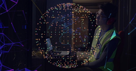 Tech wearing safety vest and headphones monitoring servers in server room, with globe, copy space