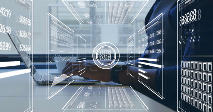 Typing man in suit reviewing holographic panels at office desk, with laptop, mug and smartwatch