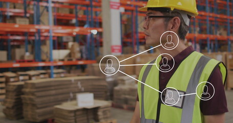 Highlighting network map over Korean worker wearing hard hat in warehouse with racks, copy space